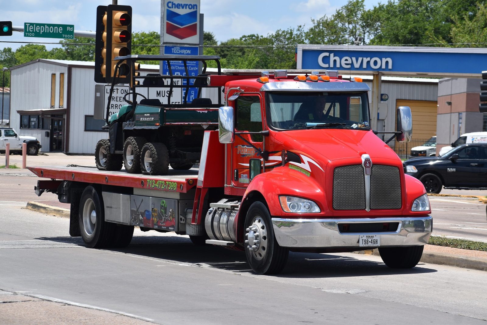 Camión transportando maquinaria pesada por carretera en Estados Unidos, relacionado con los costos de transporte y combustible.